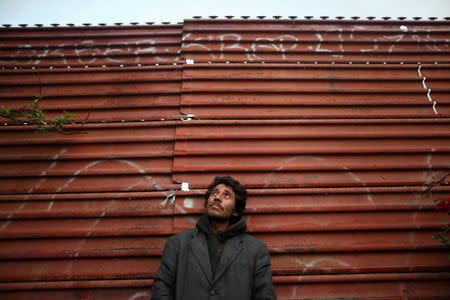 Joaquin, 36, a chef from Guatemala who says he was deported from the United States, poses for a photograph while leaning on a section of the border fence separating Mexico and the United States, in Tijuana, Mexico. REUTERS/Edgard Garrido