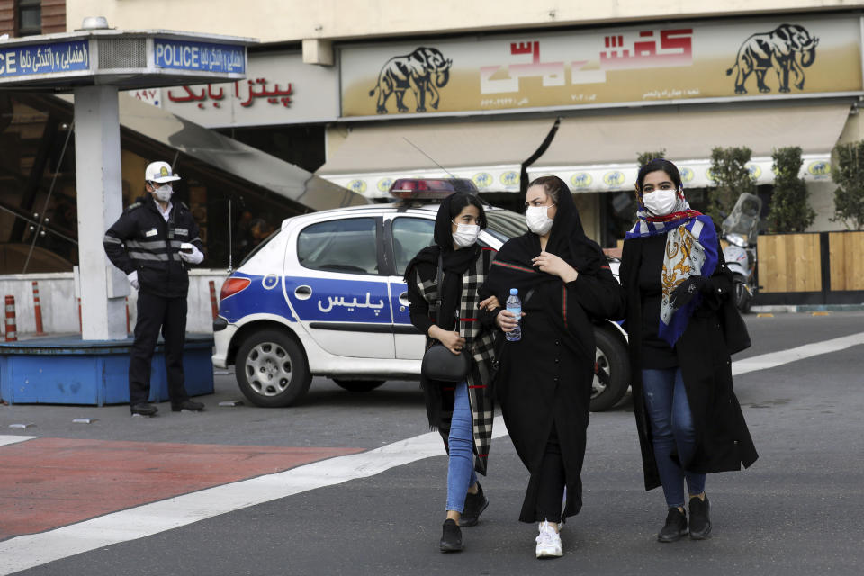 A policeman and pedestrians wear masks to help guard against the Coronavirus, in downtown Tehran, Iran, Sunday, Feb. 23, 2020. On Sunday, Iran's health ministry raised the death toll from the new virus to 8 people in the country, amid concerns that clusters there, as well as in Italy and South Korea, could signal a serious new stage in its global spread. (AP Photo/Ebrahim Noroozi)