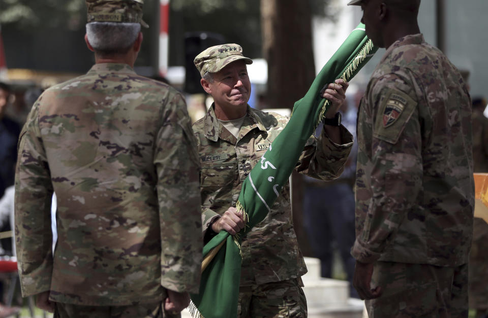 Incoming U.S. Army Gen. Austin Miller, center, receives Resolute Support's flag from outgoing U.S. Army Gen. John Nicholson, left, during the change of command ceremony at Resolute Support headquarters, in Kabul, Afghanistan, Sunday, Sept. 2, 2018. Miller has assumed command of the 41-nation NATO mission in Afghanistan following a handover ceremony. (AP Photo/Massoud Hossaini)