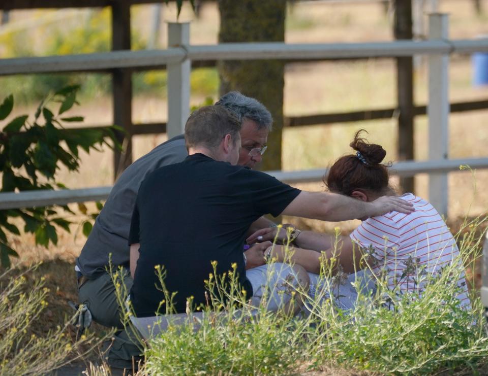 A woman is comforted close to the blaze in the village of Wennington (PA)