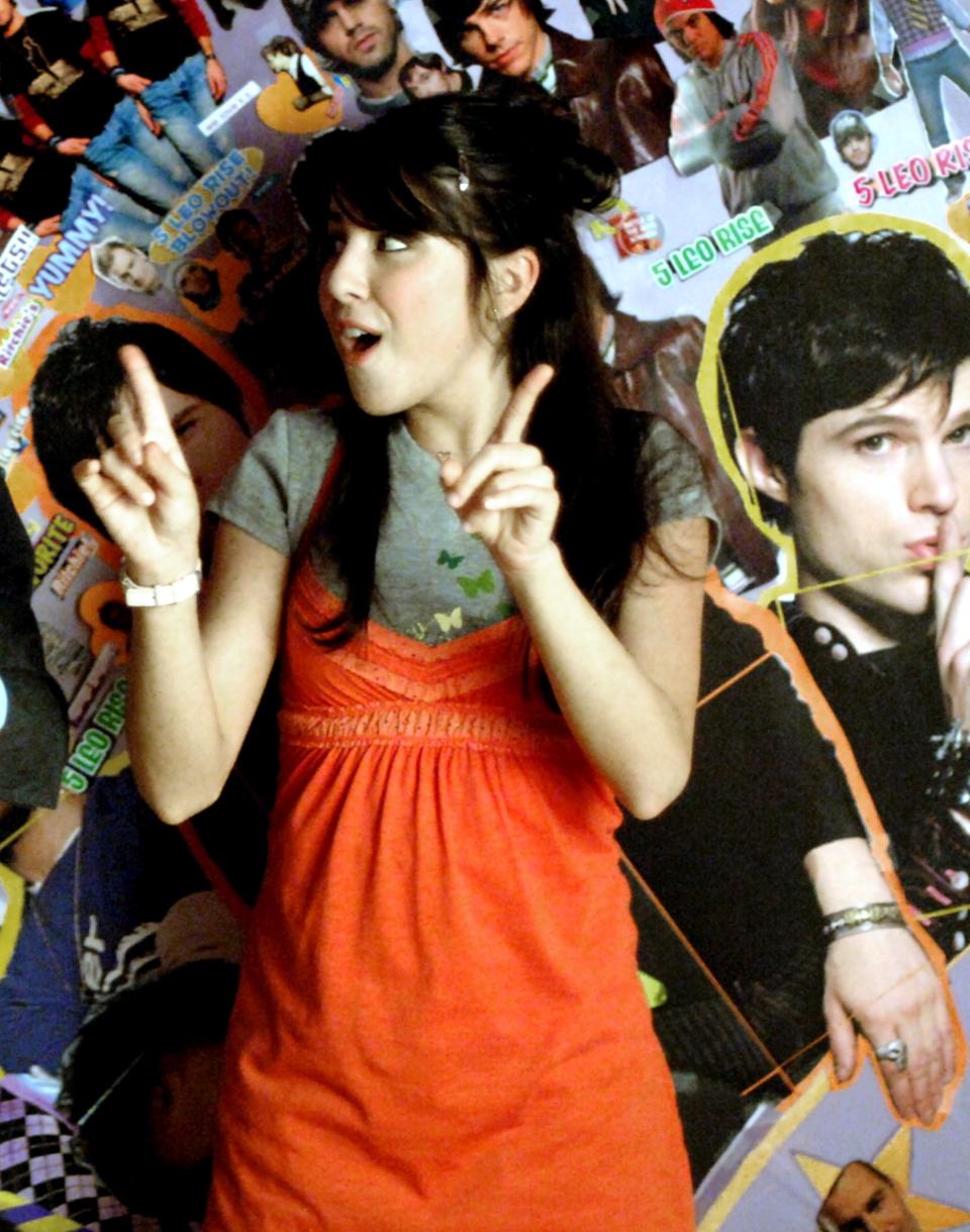 closeup of her in front of a wall of boy band posters