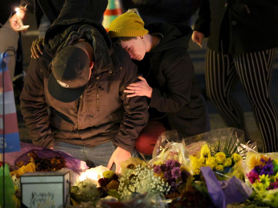 People hold a vigil at a makeshift memorial near the Club Q nightclub on November 20, 2022 in Colorado Springs, Colorado.
