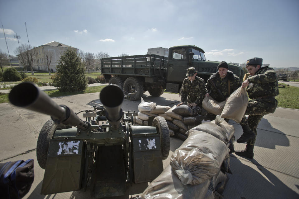 Ukrainian airmen place sand bags around an anti-aircraft gun at the Belbek air base, outside Sevastopol, Crimea, Friday, March 21, 2014. The base commander Col. Yuliy Mamchur said he was asked by the Russian military to turn over the base but is unwilling to do so until he receives orders from the Ukrainian defense ministry. (AP Photo/Vadim Ghirda)