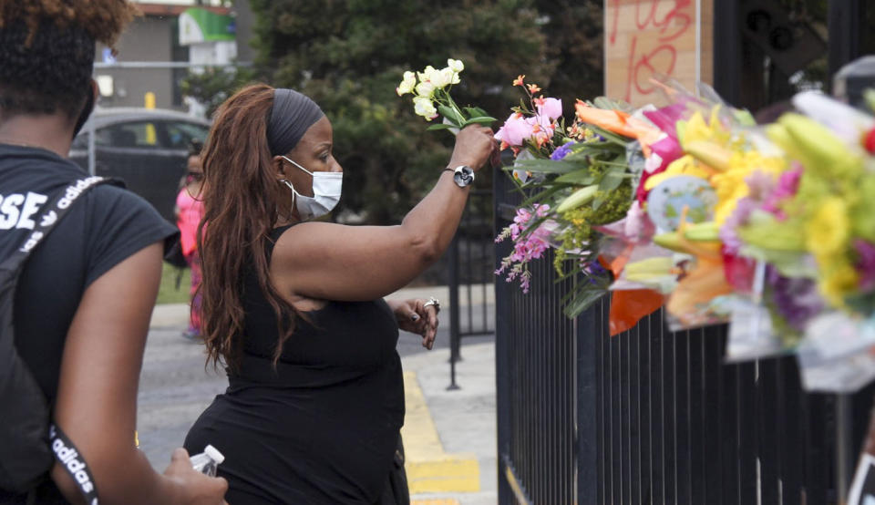 People began showing up at Wendy's in Atlanta Sunday, June 14, 2020 Some helped with cleanup, some came to look, and some began placing flowers and created a memorial at the site where Rayshard Brooks, a 27-year-old black man, was shot and killed by Atlanta police Friday evening during a struggle in a Wendy's drive-thru line. (Steve Schaefer/Atlanta Journal-Constitution via AP)