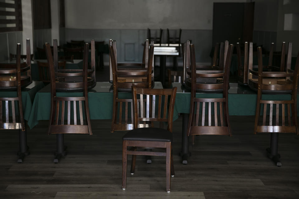 Chairs are stacked up on tables at a Peruvian restaurant open for takeout only due to the coronavirus pandemic Monday, July 6, 2020, in Los Angeles. (AP Photo/Jae C. Hong)