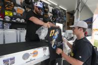 A customer looks at Kyle Larson merchandise during a practice session for the Indianapolis 500 auto race at Indianapolis Motor Speedway, Monday, May 20, 2024, in Indianapolis. (AP Photo/Darron Cummings)