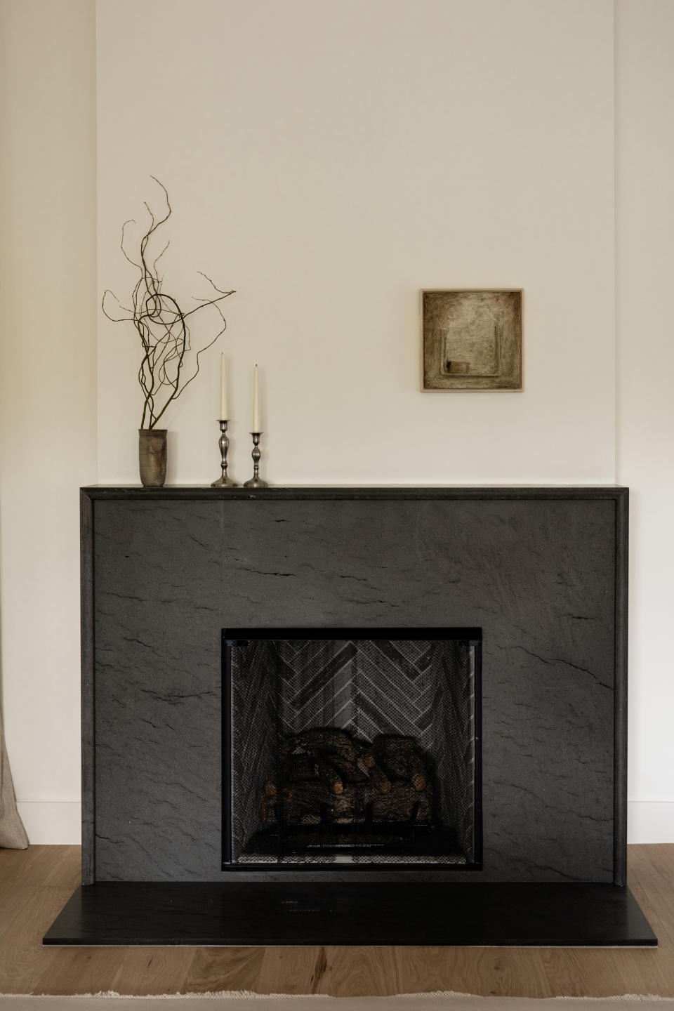 A living room fireplace with undersized wall art