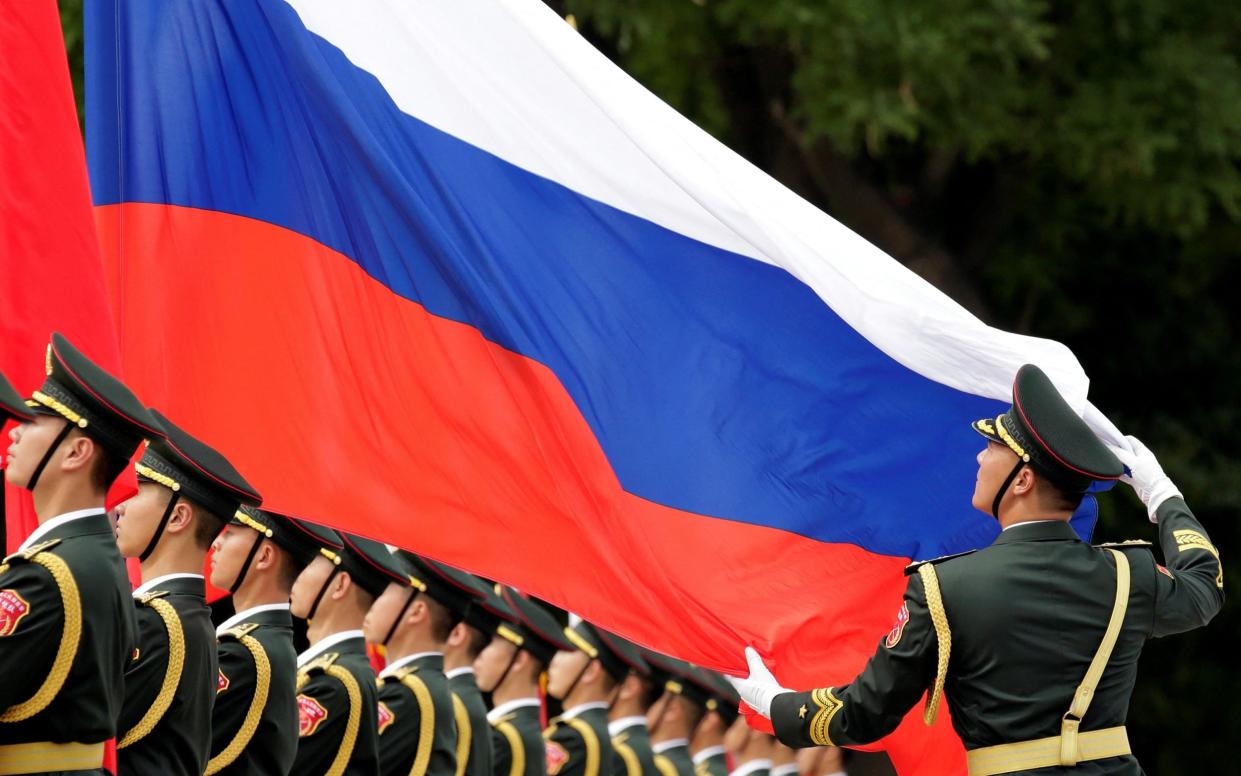 An honour guard holds a Russia flag during preparations for a welcome ceremony for Russian President Vladimir Putin outside the Great Hall of the People in Beijing in 2018 - JASON LEE /REUTERS