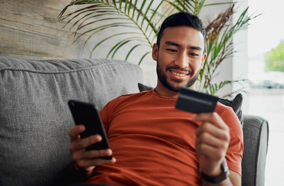 a man holding his credit card while on his phone