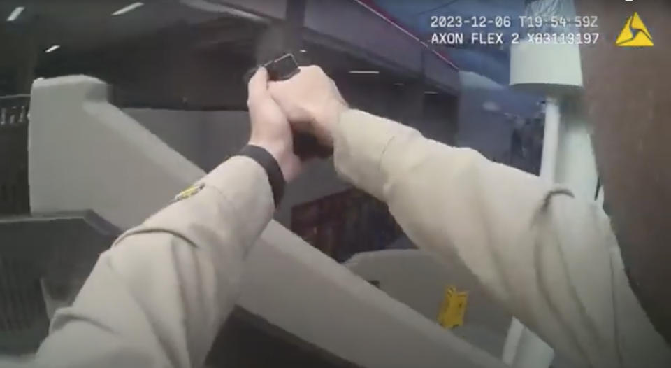 In this image made from body camera footage provided by the Las Vegas Metro Police Department, an officer holds up their gun inside a building on the University of Nevada, Las Vegas campus, Wednesday, Dec. 6, 2023, in response to reports of a shooting. Police body camera footage from the shooting, which left three people dead and one wounded, was released Wednesday, Dec. 20. (Las Vegas Metro Police Department via AP)