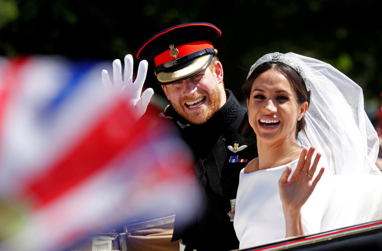 Britain’s Prince Harry and his wife Meghan wave as they ride a horse-drawn carriage after their wedding ceremony at St George’s Chapel in Windsor Castle in Windsor, Britain, May 19, 2018. REUTERS/Damir Sagolj     TPX IMAGES OF THE DAY