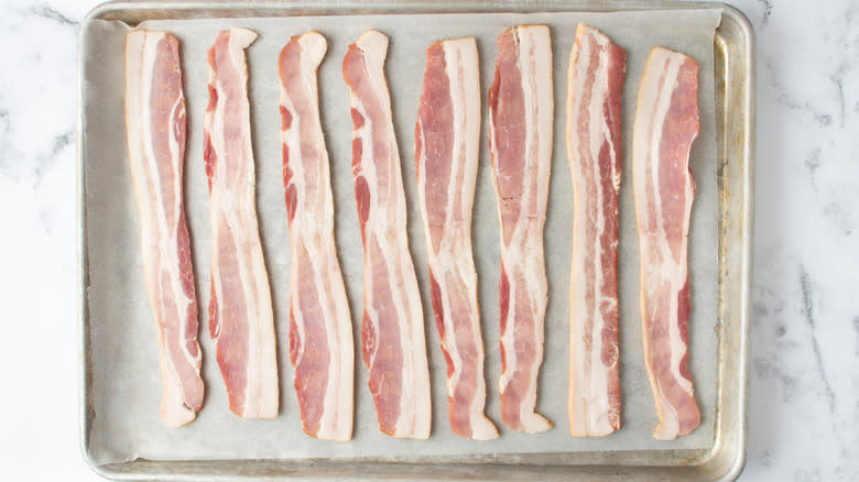 raw bacon on baking sheet