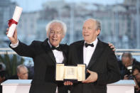 Directors Jean-Pierre Dardenne, left and Luc Dardenne hold their best director award for the film 'Young Ahmed' as they pose for photographers during a photo call following the awards ceremony at the 72nd international film festival, Cannes, southern France, Saturday, May 25, 2019. (AP Photo/Petros Giannakouris)