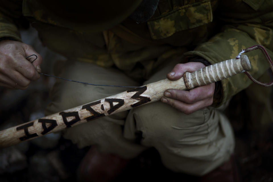 An opposition supporter engraves a baton with the words "Maidan", referring to Kiev's Independence Square, the epicenter of the country's current unrest, Ukraine, Friday, Jan. 31, 2014. Ukraine's embattled president Viktor Yanukovych is taking sick leave as the country's political crisis continues without signs of resolution. (AP Photo/Emilio Morenatti)