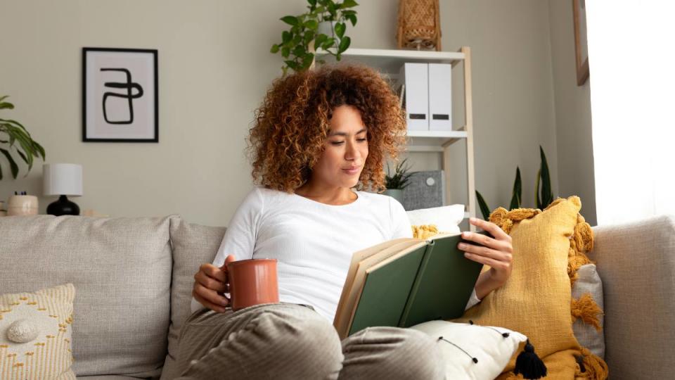 Woman trying to read more books at home with a cup of tea