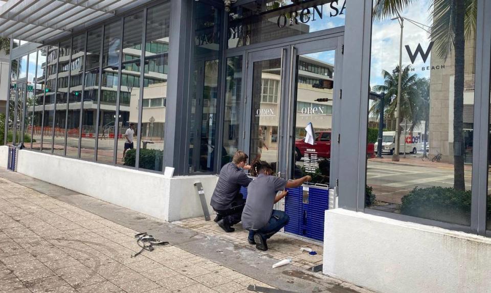 Cody Lazarz and Denton Wright, workers at the W Hotel on South Beach, install flood protection barriers on the doors of the Oren Salon, on the ground floor of the property along Collins Avenue, on Friday morning, August 13, 2021, in preparation for Tropical Depression Fred, which could strengthen to a Tropical Storm as it nears South Florida.