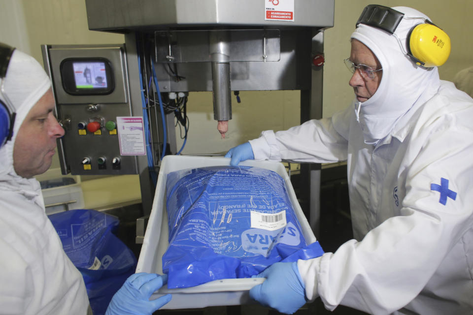 Brazil's Agriculture Minister Blairo Maggi holds a tray with a package of poultry during an inspection at the meatpacking company JBS, in Lapa, in the Brazilian state of Parana, Tuesday, March 21, 2017. Brazil's president said Tuesday that a scandal over sale of expired meat is an "economic embarrassment". On Tuesday, Hong Kong's Center for Food Safety announced that it would temporarily suspend imports of frozen and chilled meat and poultry from Brazil, starting immediately, in response to Brazilian investigators charges that health inspectors were bribed to overlook the sale of expired meats. (AP Photo/Eraldo Peres)