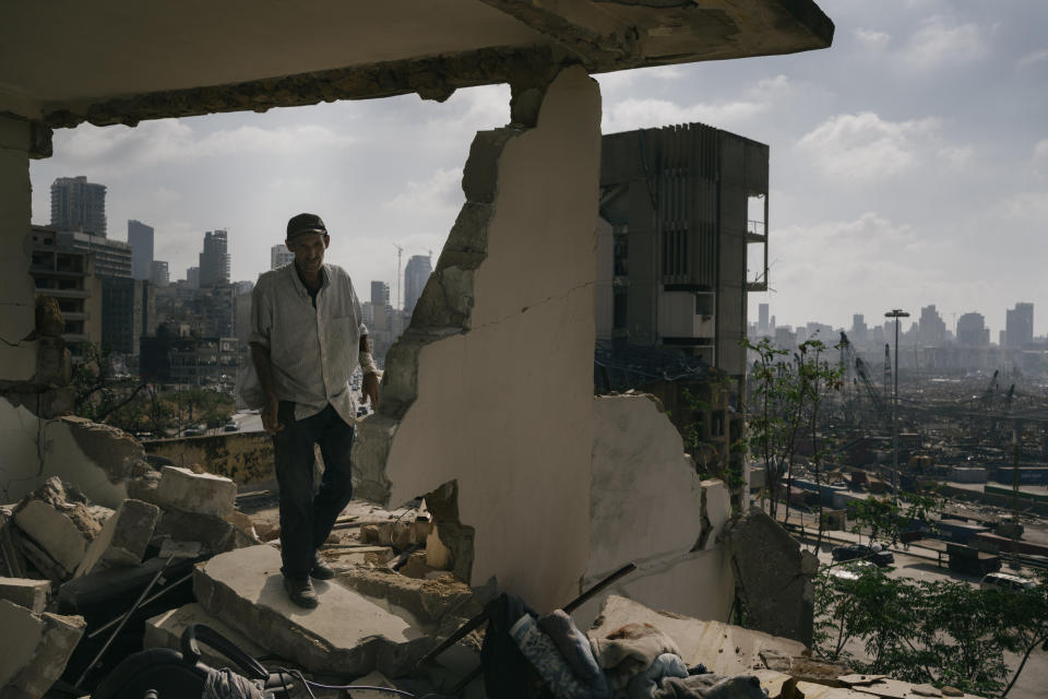 In this image released by World Press Photo, Thursday April 15, 2021, by Lorenzo Tugnoli, Contrasto, for The Washington Post, part of a series titled Port Explosion in Beirut, which won first prize in the Spot News Stories category, shows Abdullah Dalloul walks in the ruins of his former home on August 14, 2020, which was destroyed by the blast in the port of Beirut, Lebanon. Following the explosion, he and his family squatted in the damaged building with no water or electricity. (Lorenzo Tugnoli, Contrasto, for The Washington Post, World Press Photo via AP)