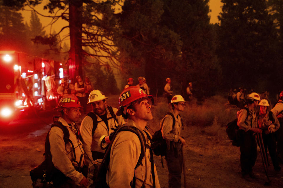 FILE - In this Thursday, Aug. 26, 2021 file photo, Capt. Adam Tinker and his crew monitor a firing operation, where crews burn vegetation to create a control line, while battling the Caldor Fire in Eldorado National Forest, Calif. Last week, managers overseeing the fight against the massive wildfire scorching California's Lake Tahoe region thought they could have it contained by the start of this week. Instead, on Monday, Aug. 30, 2021, the Caldor Fire crested the Sierra Nevada, forcing the unprecedented evacuation of all 22,000 residents of South Lake Tahoe. (AP Photo/Noah Berger, File)