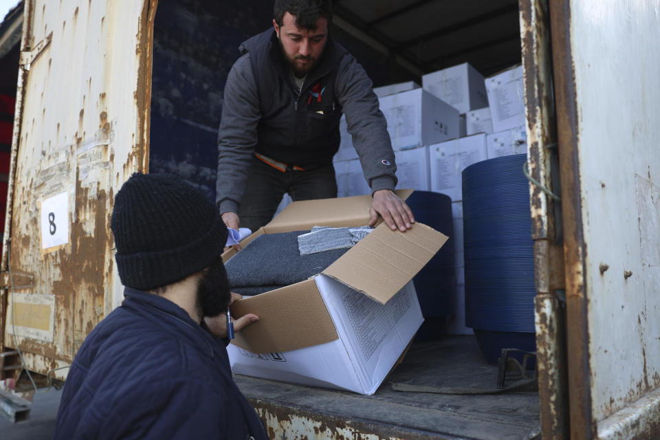 Border customs officials inspect a truck loaded with UN humanitarian aid for Syria following a devastating earthquake reach the Bab al-Hawa border crossing with Turkey, Idlib province, Syria, Friday, Feb. 10, 2023. Rescuers pulled several people alive from the shattered remnants of buildings on Friday, some who survived more than 100 hours trapped under crushed concrete in the bitter cold after a catastrophic earthquake slammed Turkey and Syria. (AP Photo/Ghaith Alsayed)