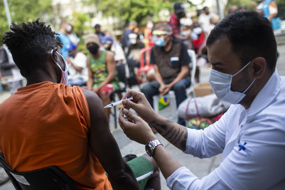 A man gets a shot of the AstraZeneca vaccine for COVID-19 during a vaccination program for the homeless at a public square in Rio de Janeiro, Brazil, Thursday, May 27, 2021. (AP Photo/Bruna Prado)