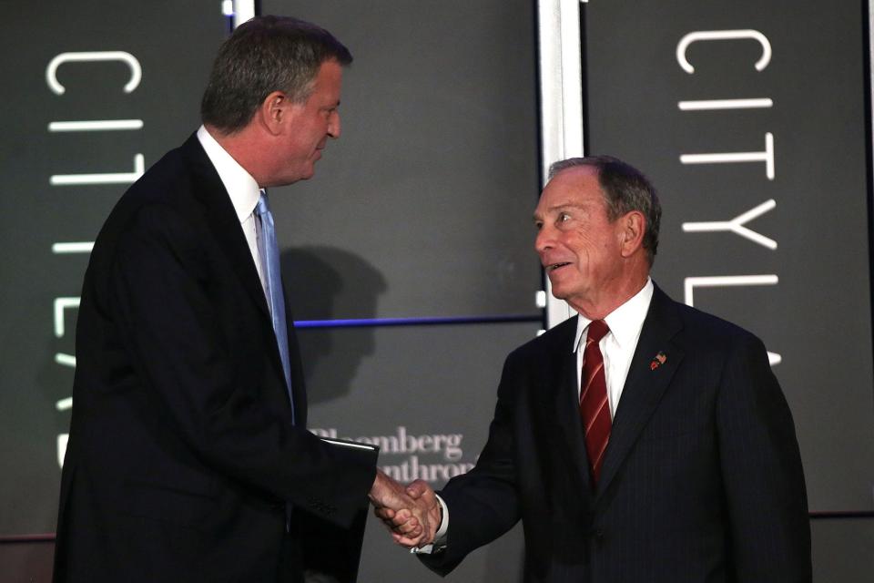 New York Mayor Bill de Blasio (L) appears on stage with Michael Bloomberg in 2013.