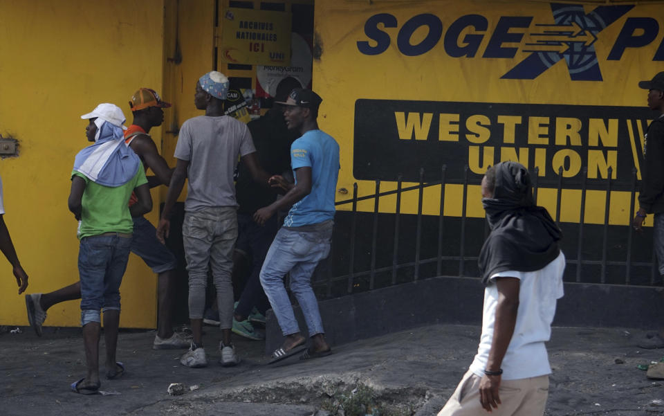 Protesters loot a money transfer office during a protest demanding the resignation of President Jovenel Moise in Port-au-Prince, Haiti, Thursday, June 13, 2019. The demonstration came a day after Moïse broke his silence over the country’s recent unrest and rejected demands that he step down over allegations of officials misusing funds from subsidized oil shipments from Venezuela under the Petrocaribe program. (AP Photo/Edris Fortune)