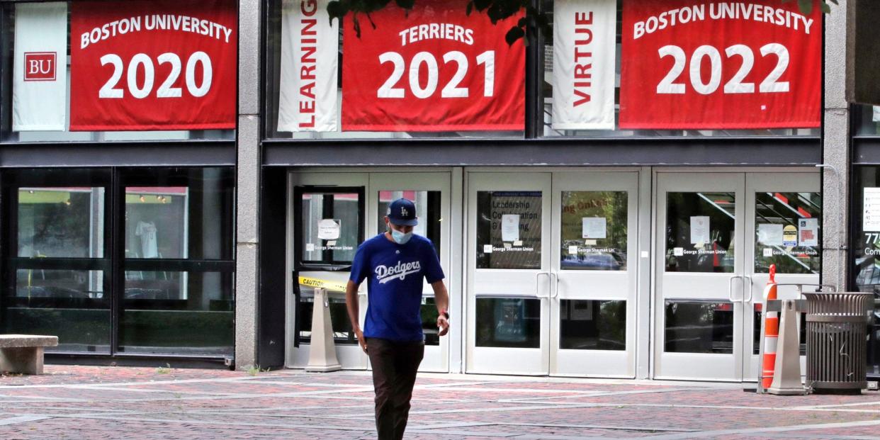 In this July 23, 2020, file photo, Weston Koenn, a graduate student from Los Angeles, leaves the Boston University student union building as he walks through the student-less campus in Boston.