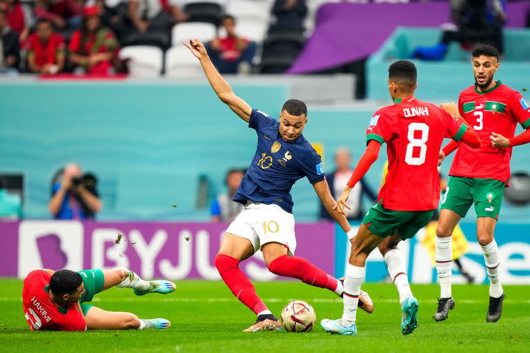 Kylian Mbappé patea ante la presión de los marroquíes en el partido entre Marruecos y Francia por las semifinales del Mundial de Qatar
