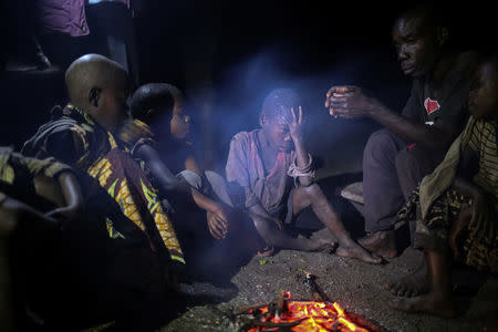 People gather around a fire in Kagorwa Pygmy camp on Idjwi island in the Democratic Republic of Congo, November 23, 2016. REUTERS/Therese Di Campo