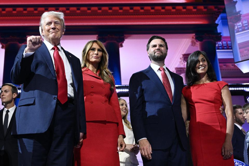 Former president and 2024 Republican presidential candidate Donald Trump raises a fist next to former U.S. First Lady Melania Trump, Republican vice-presidential candidate JD Vance and his wife, lawyer Usha Chilukuri Vance, during the last day of the 2024 Republican National Convention at the Fiserv Forum in Milwaukee, Wisconsin, on July 18, 2024.