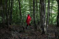 A migrant from Bangladesh walks through the woods near Velika Kladusa