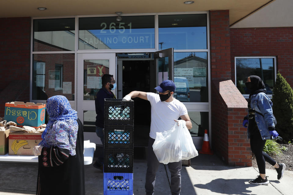 In this Friday, May 1, 2020 photo, workers at ACCESS, the Arab Community Center for Economic and Social Services, help with meals for the Arab community in Dearborn, Mich. As state officials and nonprofit groups target hard-to-count groups in the 2020 Census, like immigrants, many Arab Americans say the undercount is even more pronounced for them. That means one of the largest and most concentrated Arab populations outside the Middle East — those in the Detroit area — could be missing out on federal funding for education, health care, crime prevention and other programs that the census determines how to divvy up. (AP Photo/Carlos Osorio)