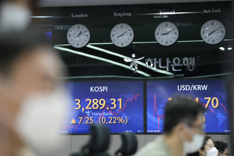 Currency traders watch computer monitors near screens showing the Korea Composite Stock Price Index (KOSPI), left, and the foreign exchange rate between U.S. dollar and South Korean won at a foreign exchange dealing room in Seoul, South Korea, Friday, July 2, 2021. Shares were mostly higher in Asia on Friday, though markets in Shanghai and Hong Kong declined a day after the Chinese Communist Party marked its centenary with tough talk by Chinese President Xi Jinping. (AP Photo/Lee Jin-man)