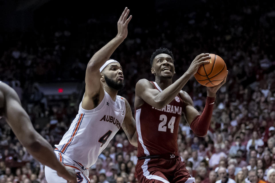 Alabama forward Brandon Miller (24) looks for a shot as Auburn forward Johni Broome (4) defends during the first half of an NCAA college basketball game Wednesday, March 1, 2023, in Tuscaloosa, Ala. (AP Photo/Vasha Hunt)