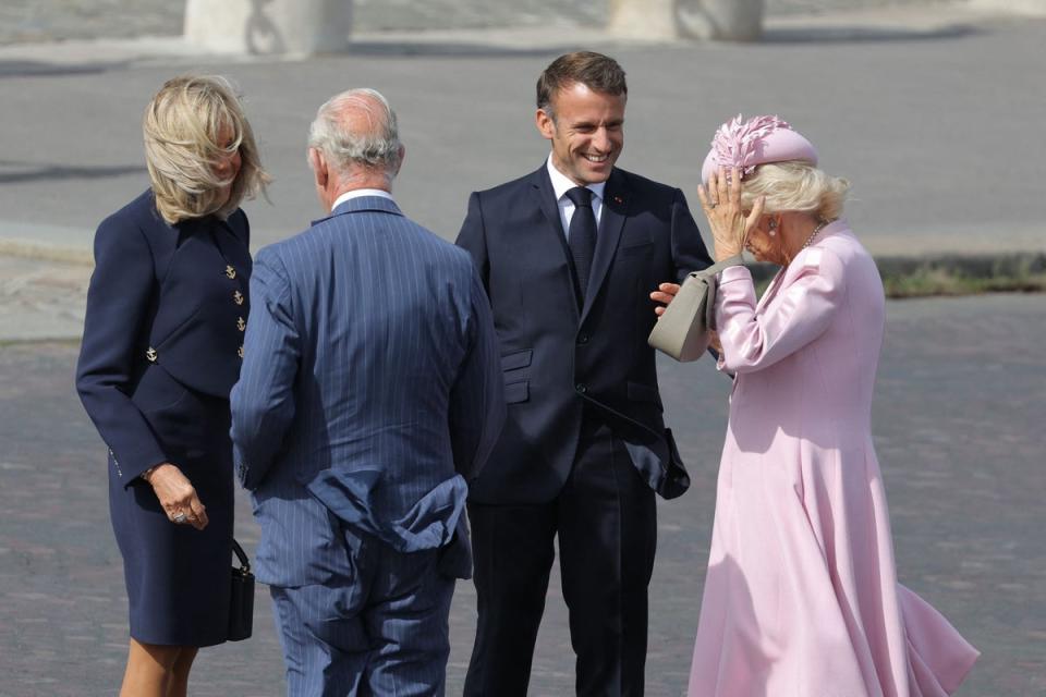 Hold onto your hat: The Queen keeps her pink beret-style hat by milliner Philip Treacy in place amid the gusty conditions (AFP via Getty Images)