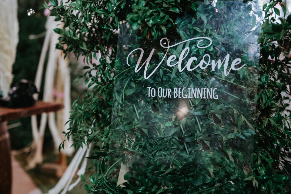 Sign among greenery reads, "Welcome to our beginning"