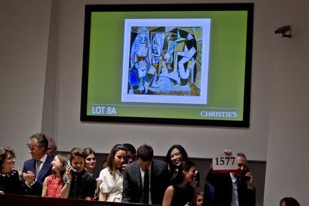 A Christie's employee hold up the winning paddle number for Pablo Picasso's "Les femmes d'Alger (Version 'O')" (Women of Algiers) at Christie's Auction House in the Manhattan borough New York May 11, 2015. REUTERS/Carlo Allegri