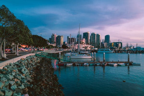 Wondering where to stay in San Diego? Our guide will give you a rundown of all the neighborhoods and city districts. Picture here is a night time view of San Diego's beautiful coast.