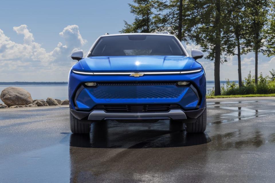 front view of 2024 chevrolet equinox ev 3lt in riptide blue parked in front of a lake preproduction model shown actual production model may vary visit chevycomequinoxev for availability