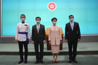 Hong Kong's Chief Executive Carrie Lam, second right, poses with Chief Secretary John Lee, second left, Secretary for Security Chris Tang, and Commissioner of Police Raymond Siu during a news conference in Hong Kong, Friday, June 25, 2021. China on Friday promoted Hong Kong’s top security official to the territory’s No. 2 spot as Beijing continues to clamp down on free speech and political opposition. (AP Photo/Kin Cheung)