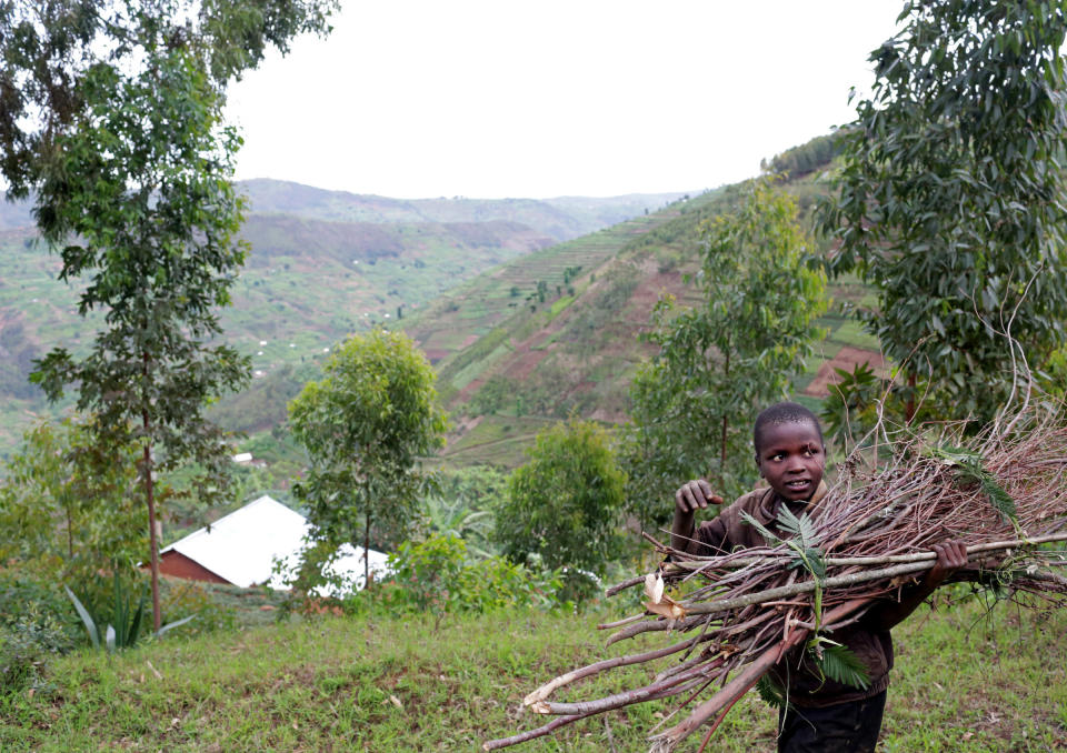 A child carries wooden sticks by a road snaking through Mount Kigali, Rwanda on November 15, 2017. (Photograph by Yana Paskova)  