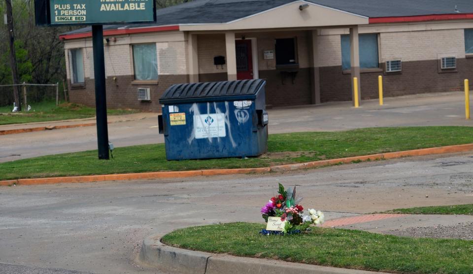 Flowers serve as a memorial near the Relax Inn.