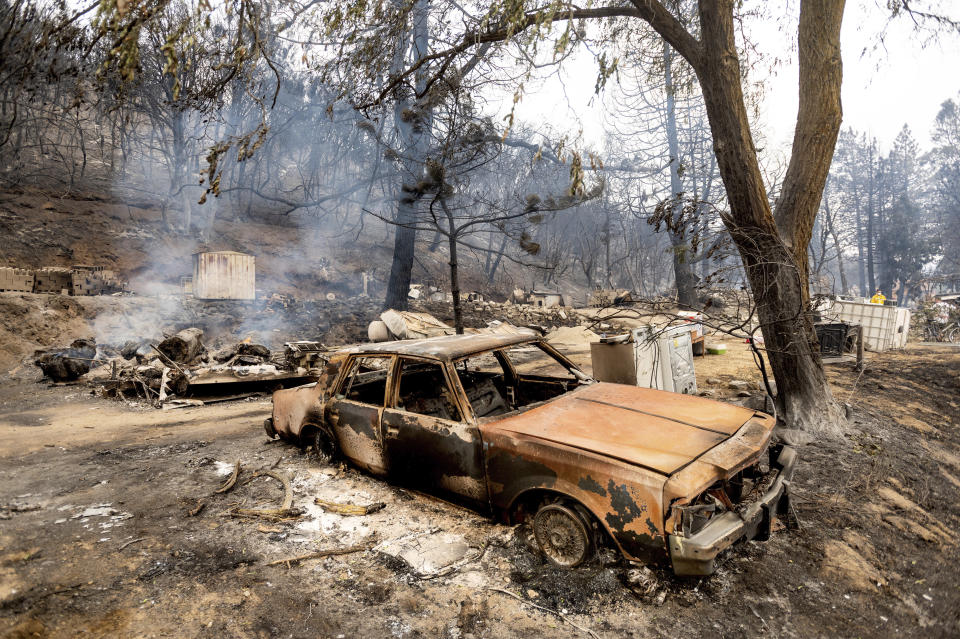 A burned vehicle rests along Pine Canyon Rd. as the Lake Fire burns in the Angeles National Forest, Calif., north of Santa Clarita on Thursday, Aug. 13, 2020. (AP Photo/Noah Berger)