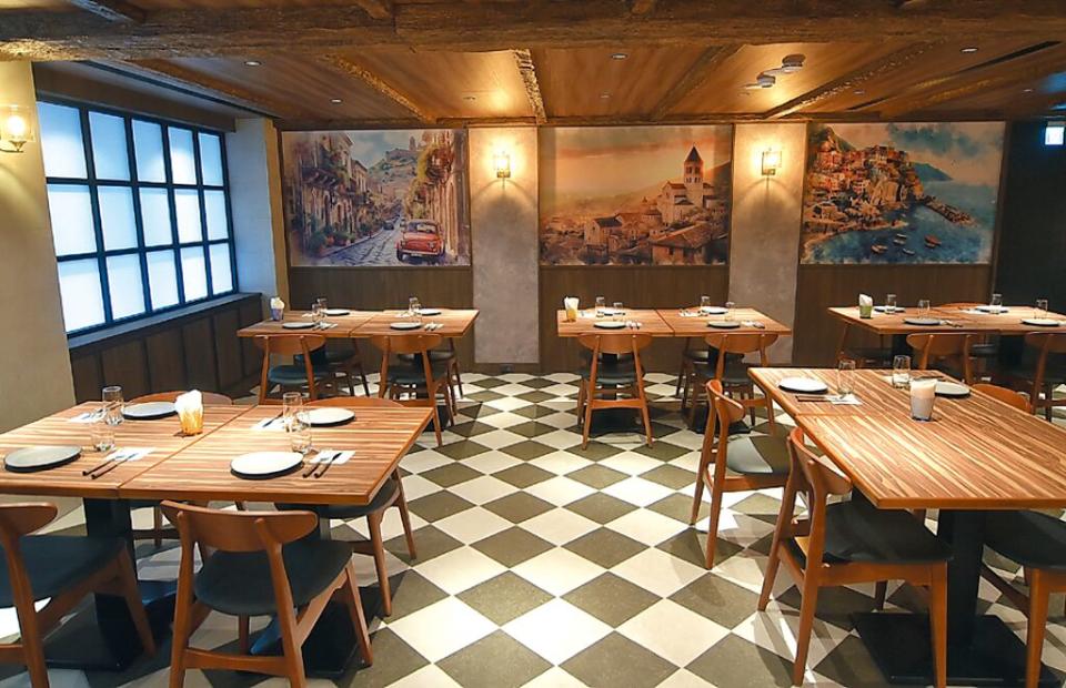 開在台北市仁愛圓環商圈的〈Reale Cucina Italiana〉義式餐廳的裝潢，以木桌木椅、黑白交錯菱格地磚、風景壁畫，打造置身義大利酒窖或古堡的氛圍 圖／姚舜。