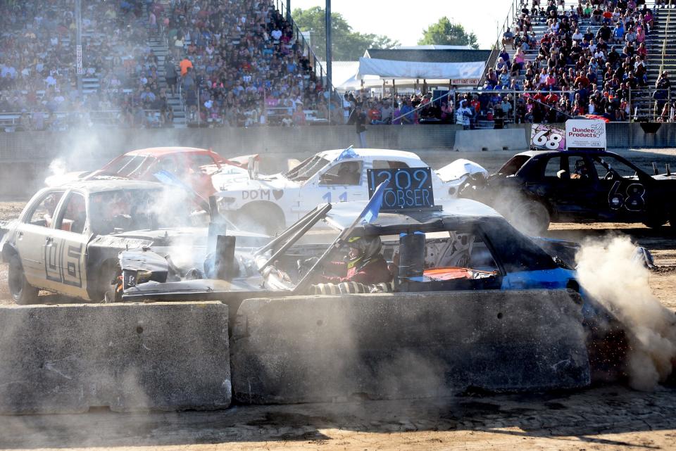 Scott Wobser, of Ida, in the 1209 car, takes a hit in an early heat during the 6 p.m. show Tuesday evening at the 49th annual Monroe County Fair Demolition Derby.