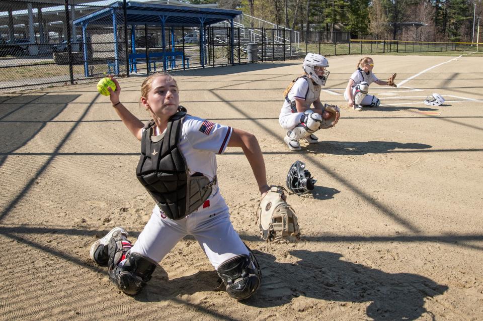 Lincoln-Sudbury varsity softball catchers (from left) senior Marissa Mazzocchi, sophomore Ashleigh Lent and her sister, freshman Nicole Lent, warm up before the game in Sudbury against Holliston, April 13, 2023. 
