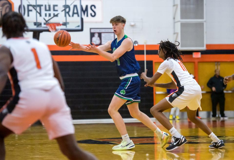 Peoria Notre Dame's Eoin Dillon, left, passes the ball as Manual's Dietrich Richardson guards in the first half Friday, Dec. 2, 2022 at Manual High School. The Rams defeated the Irish 47-29.