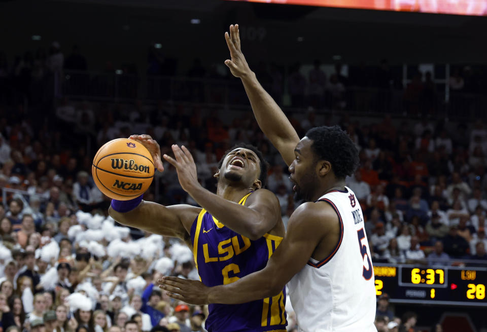 LSU guard Jordan Wright (6) is fouled by Auburn forward Chris Moore (5) during the first half of an NCAA college basketball game Saturday, Jan. 13, 2024, in Auburn, Ala. (AP Photo/Butch Dill)