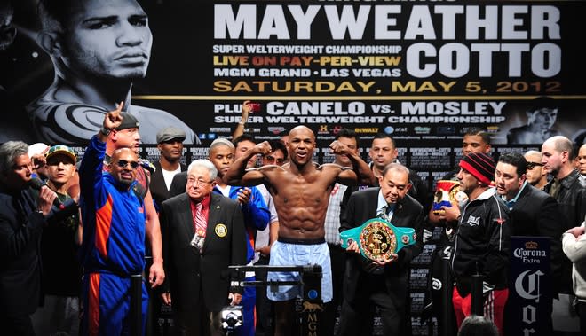 US boxer Floyd Mayweather gestures on the scales during the weigh-in on May 4, 2012 in Las Vegas, Nevada ahead of the Super Welterweight championship fight against Puerto Rico's Miguel Cotto on May 5. AFP PHOTO/Frederic J. BROWNFREDERIC J. BROWN/AFP/GettyImages